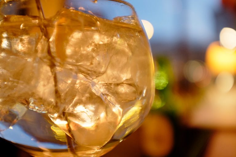 Bernsteinfarbener Drink mit Eis im Ballonglas – il Bar Konstanz
